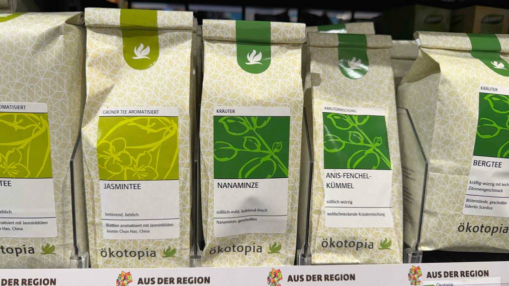 Mehrere Verpackungen mit Nanaminze im Test; Jasmin Tee und Anis-Fenchel-Kümmel-Mischung stehen auf einem Verkaufsregal.
