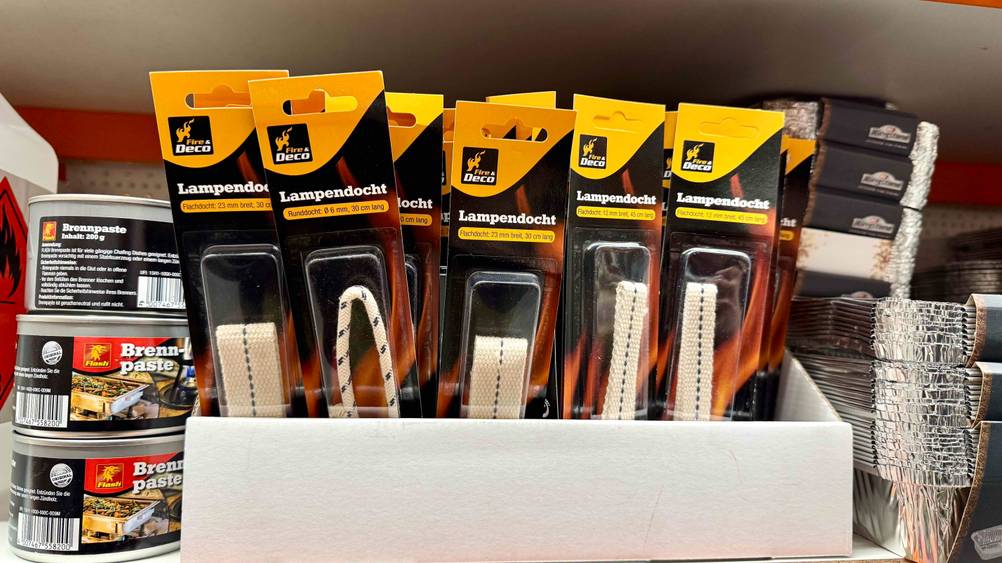 Mehrere getestete Öllampendochte in einem Karton in einem Verkaufsregal.