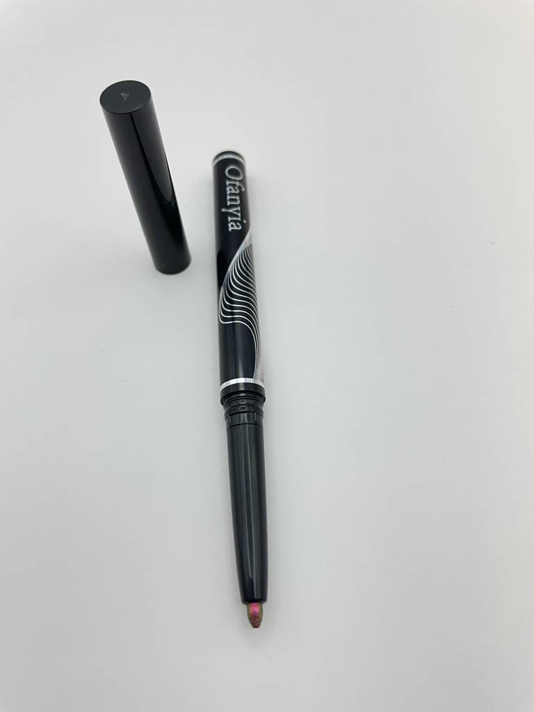 Ein getesteter Gel-Eyeliner liegt neben seiner Verschlusskappe auf einer weißen Oberfläche.