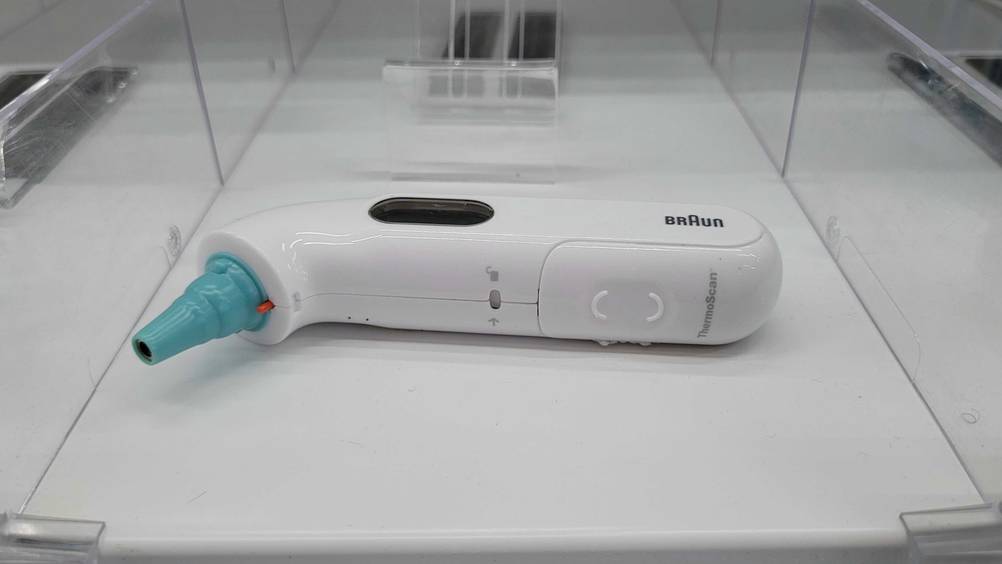 Ein Ohrthermometer im Test liegt auf der Seite in einem Verkaufsregal.
