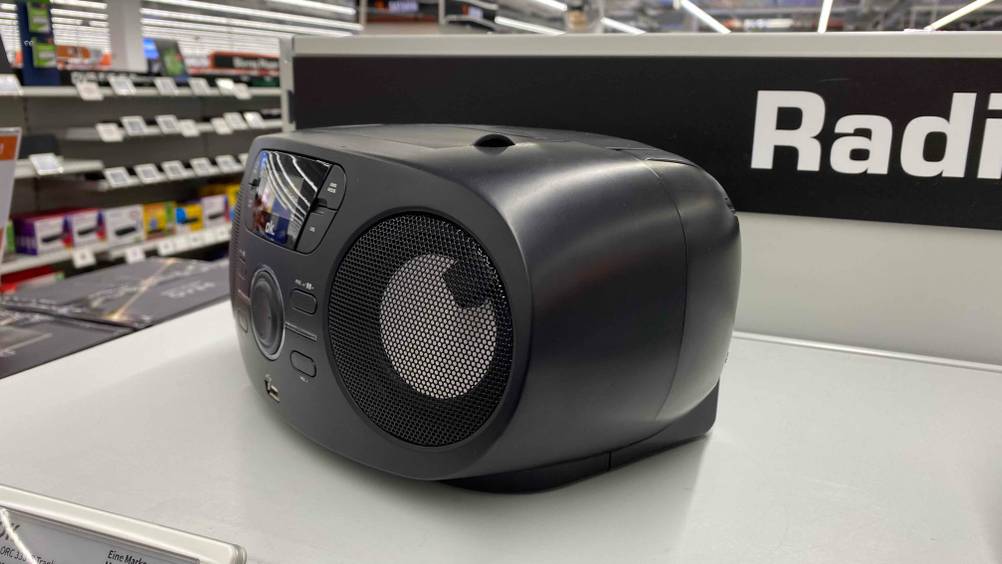 CD-Radio getestet: Ein Gerät von der rechten Seite auf einem weißen Regalbrett in einer Verkaufsfläche.