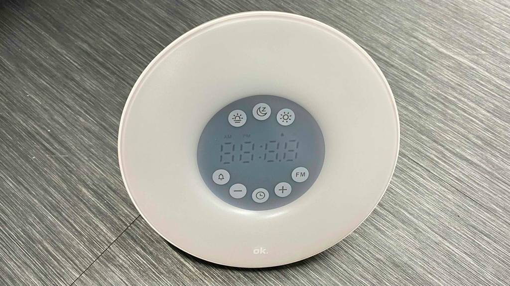 Lichtwecker-Test: ein weißes, rundes Modell von ok. mit digitaler Anzeige und Tastatur befindet sich auf einem grauen Untergrund.