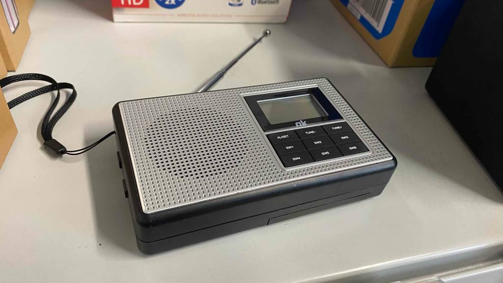 Taschenradio im Test: ein Gerät von OK liegt flach mit ausgezogener Antenne in einem Regal.