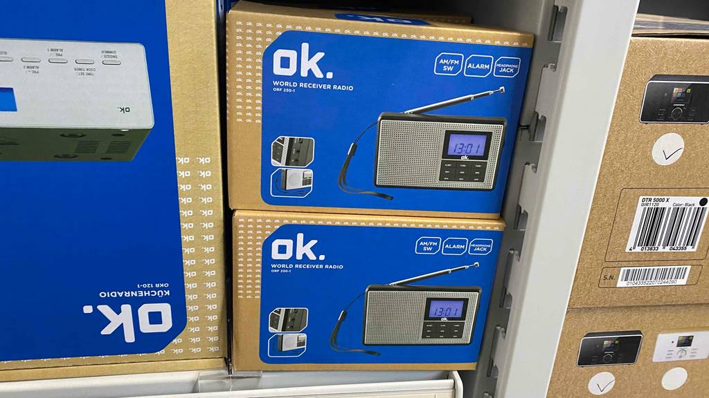 Ok Taschenradio im Test: mehrere Verpackungen gestapelt neben anderen Radios in einem Regal.