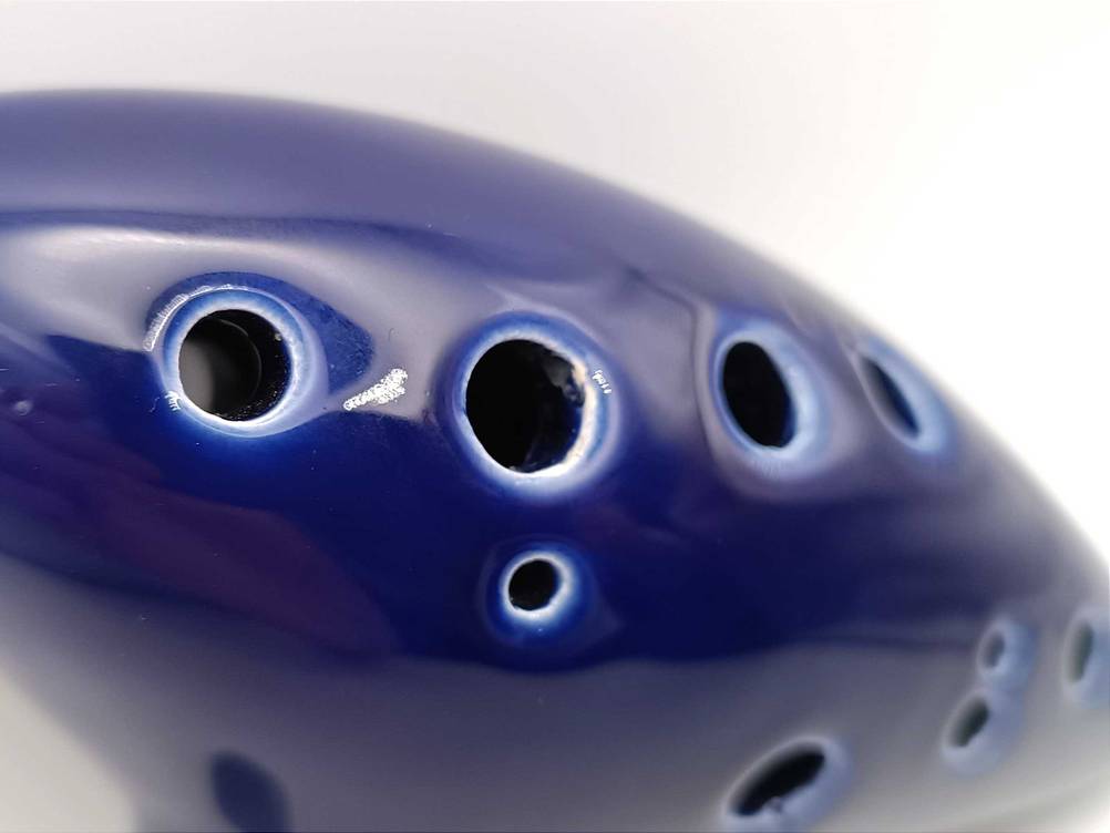 Nahaufnahme der Löcher einer getesteten Okarina in Blau.