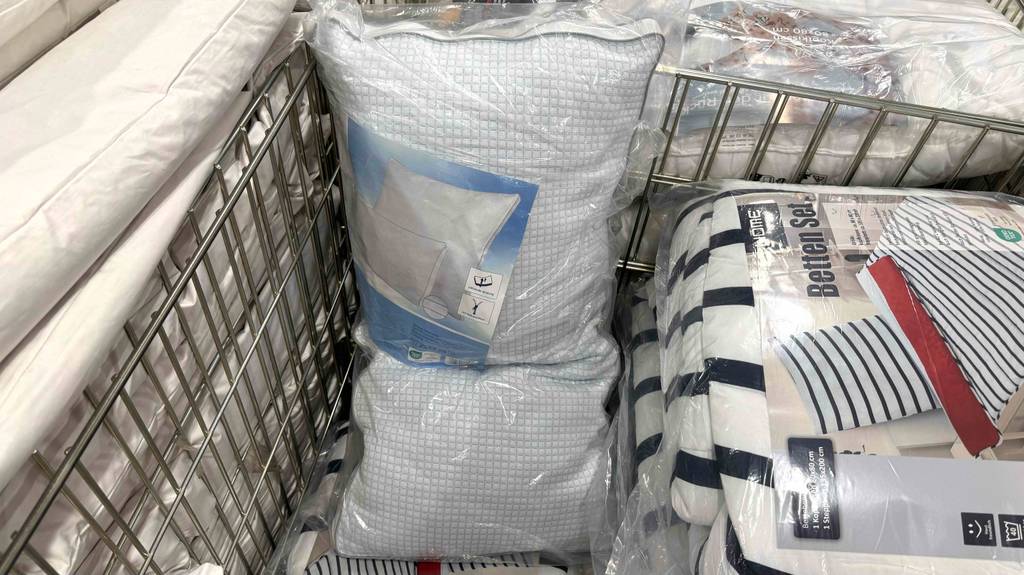 Kühlende Kopfkissen im Test: ein schmales Modell liegt original verpackt in einem Korb mit Bettwäsche im Geschäft.
