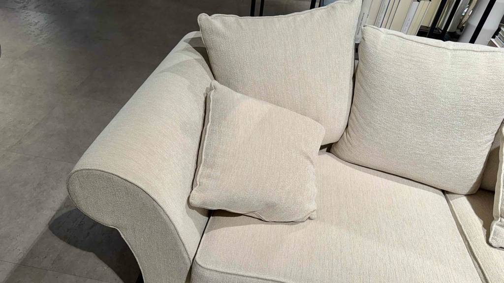 Detailansicht des hellen Stoffbezugs, der sich auf einem 3-Sitzer Sofa im Test befindet.