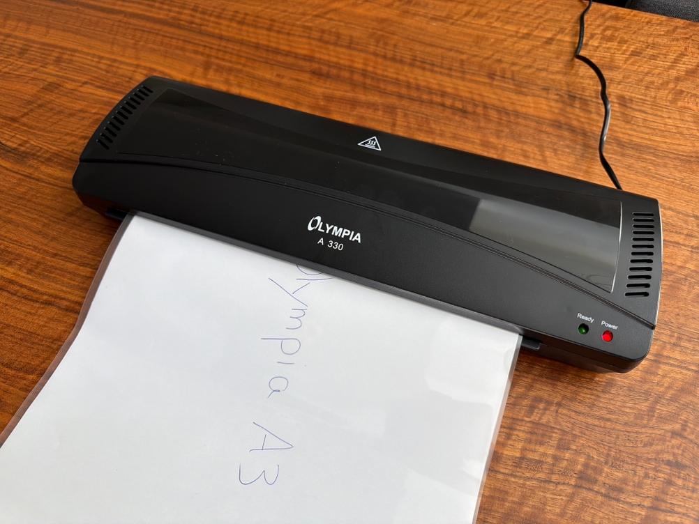 Ein beschriebenes weißes Blatt ist im Olympia A 330 Laminierer.