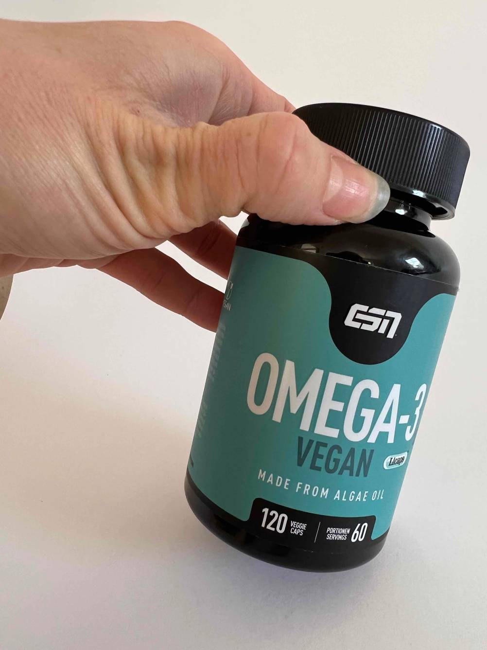 Eine Hand hält eine Dose der getesteten Omega-3-Kapseln.