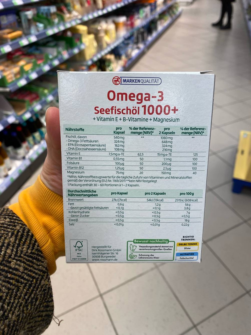 Omega-3-Öl getestet: Eine Hand hält die Rückseite der Packung nach vorne.