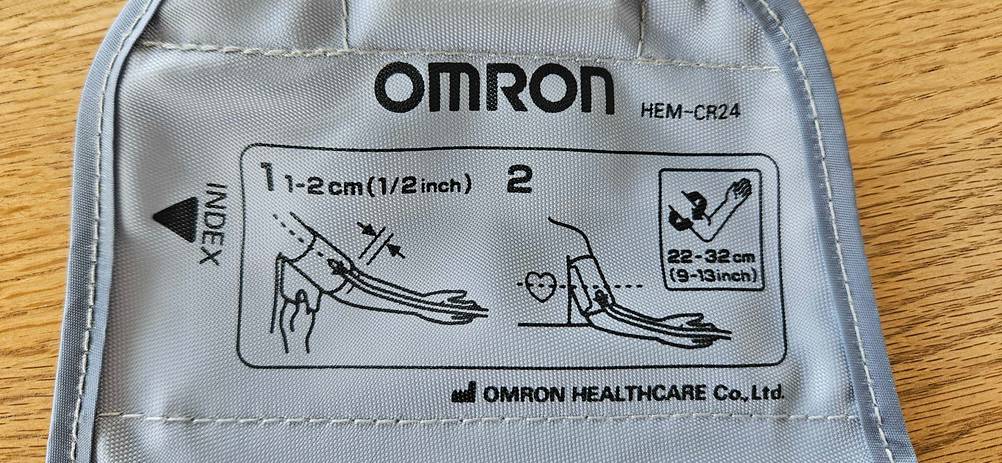 Nahaufnahme der Infografik auf der Manschette eines getesteten Omron-Blutdruckmessgerätes.