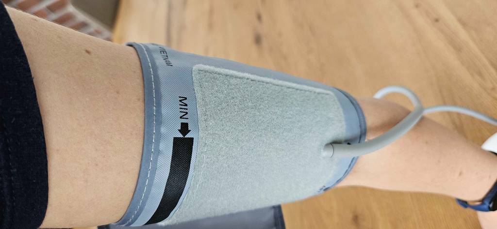 Manschette des getesteten Omron-Blutdruckmessgeräts ist am Arm angebracht.