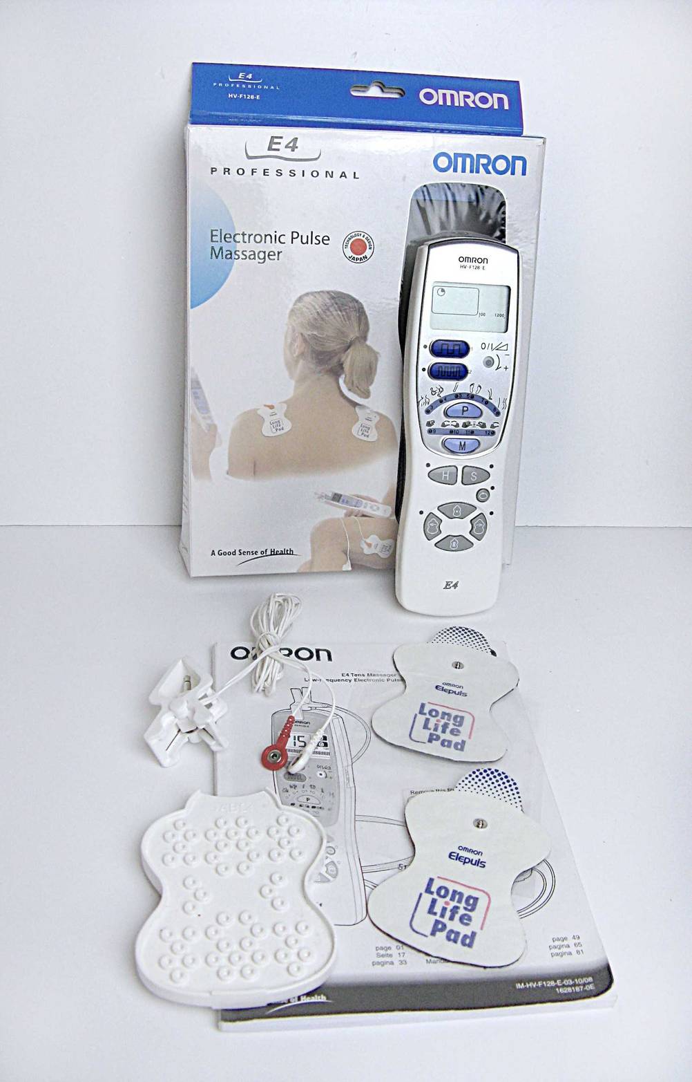 Getestete: Das Reizstromgerät steht vor der Verpackung. Davor liegen die Pads sowie die Verbindungskabel und die Gebrauchsanweisung.