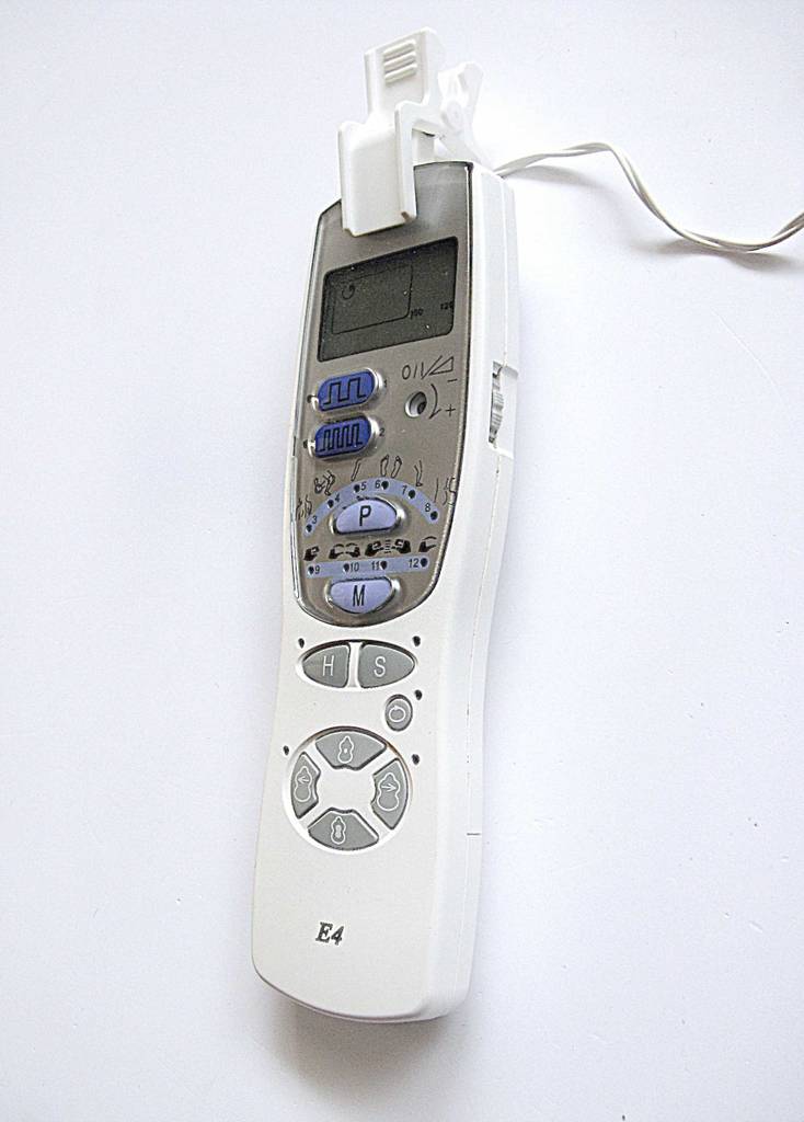 Getestet: Das Reizstromgerät mit intuitiver Programmwahl und LCD-Display liegt verkabelt auf einer weißen Oberfläche.