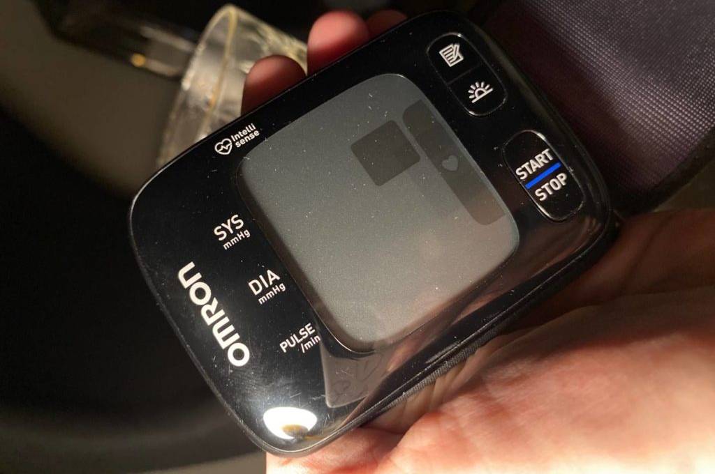 Omron-Blutdruckmessgerät im Test: Nahaufnahme eines schwarzen Modells in einer linken Hand.