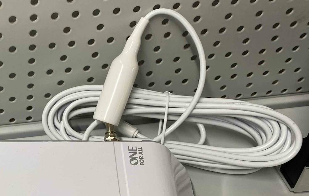 Weiße One for All DVB-T2-Außenantenne im Test mit Fokus auf das flexibel bewegliche Anschlusskabel.