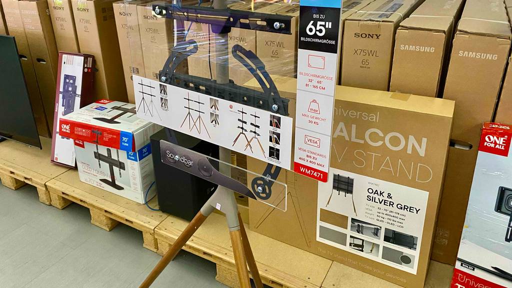 Ein TV-Ständer für 65 Zoll steht zum testen vor vielen Originalverpackungen.