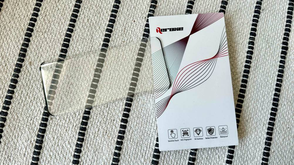 Getestet: Ein OnePlus-8-Pro-Panzerglas liegt auf seiner Originalverpackung auf einem Teppich.
