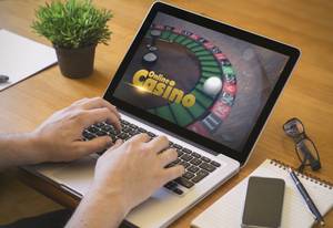 person spielt im online casino am laptop