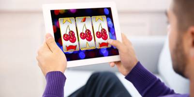 mann spielt gluecksspiel am tablet