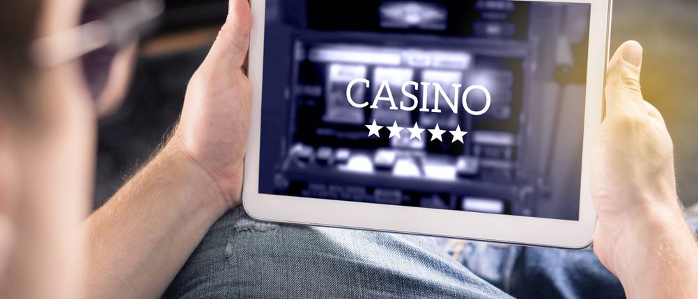 hand haelt tablet mit online gluecksspiel