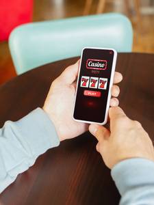 person spielt lotto online am handy