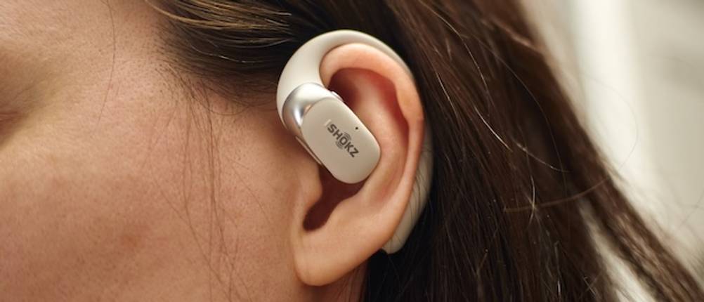 Open-Ear-Kopfhörer-Test: Ein weißer Open-Ear-Kopfhörer mit Bügel von Shokz auf einem Damenohr.