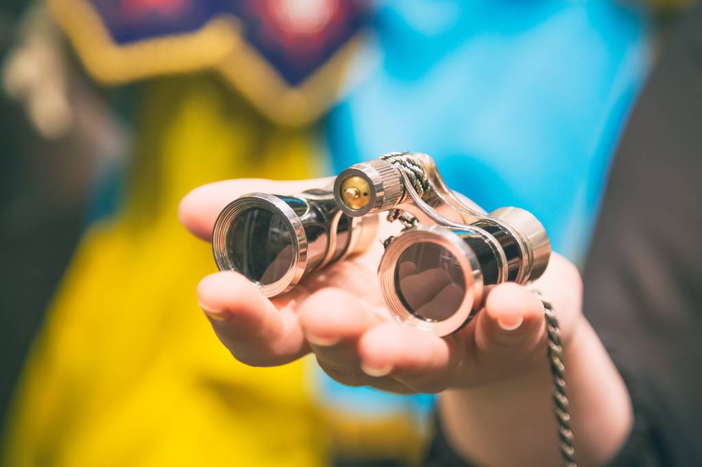 Opernglas-Test: Eine Frau hält ein kleines Opernglas in der Hand. 