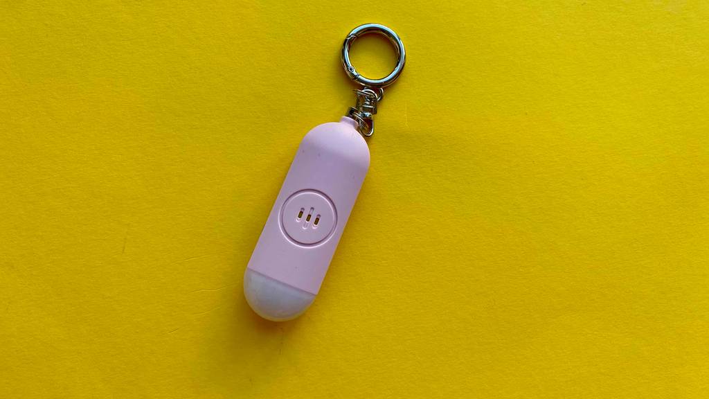 Ein getesteter Taschenalarm liegt auf einer gelben Unterfläche.