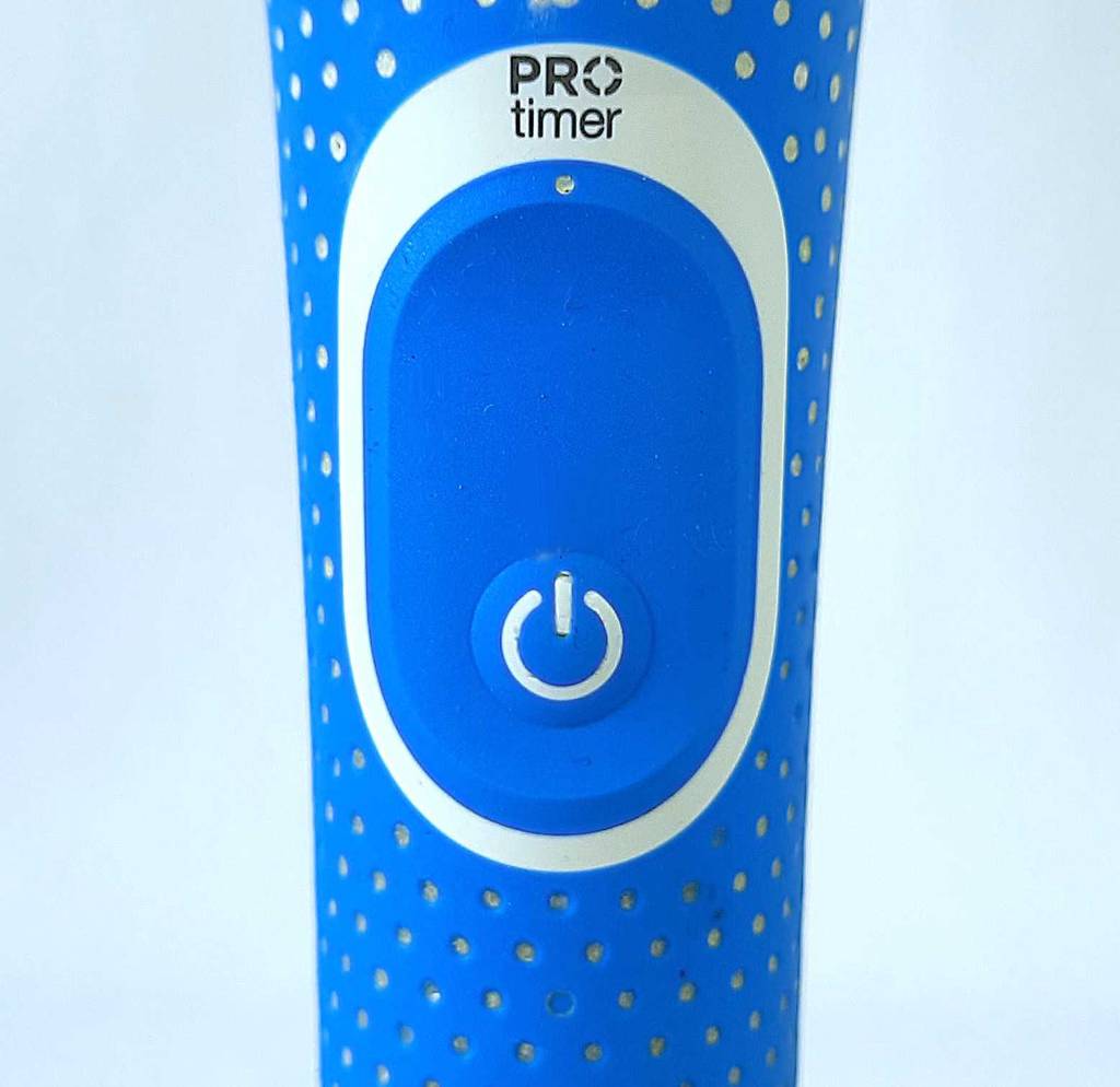 Rotierende Zahnbürste im Test. Detailansicht der Betriebstaste.