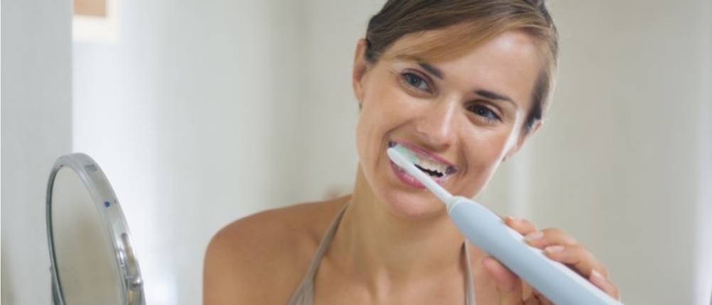 oral b elektrische zahnbuerste frau putzt zaehne grau spiegel