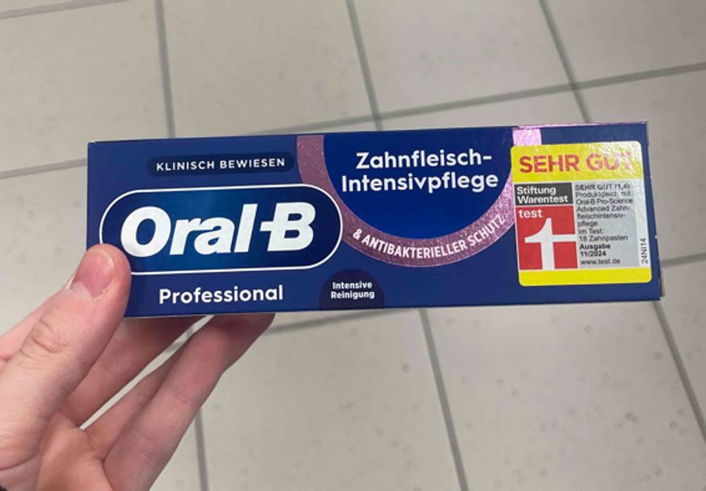 Im Test: Eine Hand hält eine Packung Oral-B-Zahnpasta Professional.