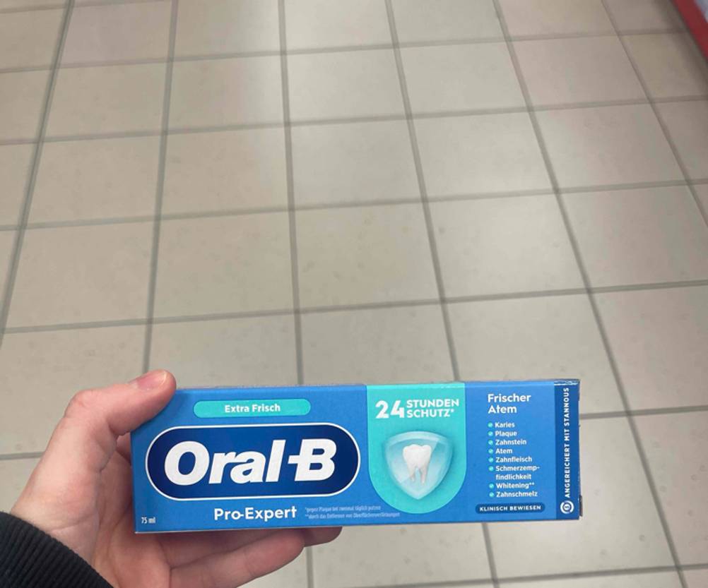Eine Hand hält die Verpackung von getesteter Oral-B-Zahnpasta der Sorte Pro Expert.