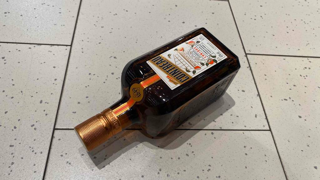 Auf dem Boden liegt eine Flasche getestetes Orangenlikör.