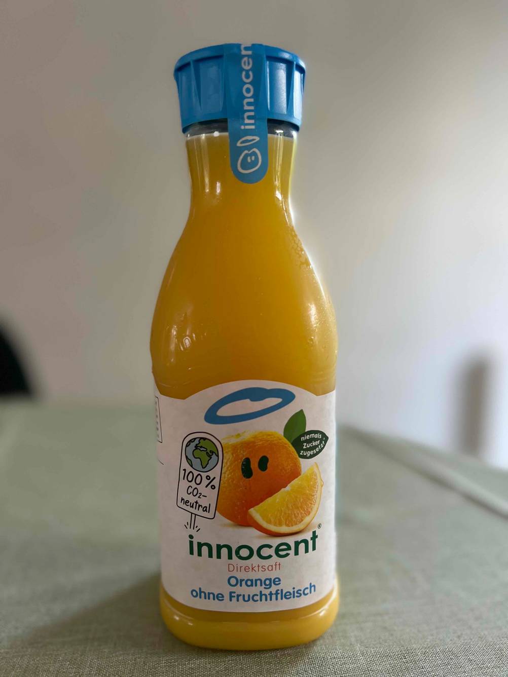 Im Test: Eine Flasche Orangensaft von vorne auf einer grauen Fläche.