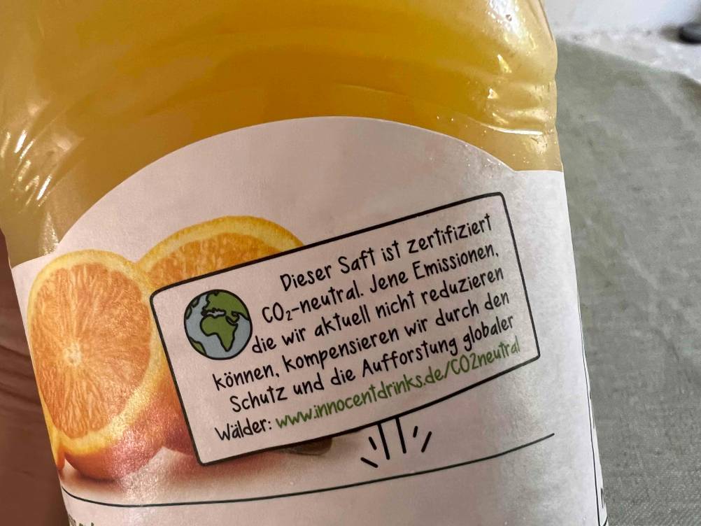 Nahaufnahme des Aufdrucks zur CO2-Neutralität auf dem Label einer Flasche des getesteten Orangensaftes.