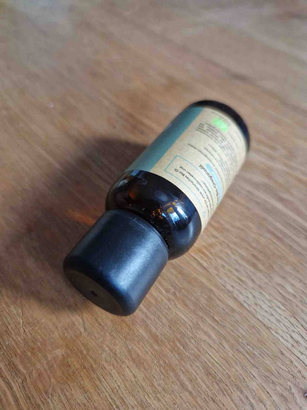Oregano-Öl im Test: Nahaufnahme der Verschlusskappe einer Flasche auf einer Holzfläche.