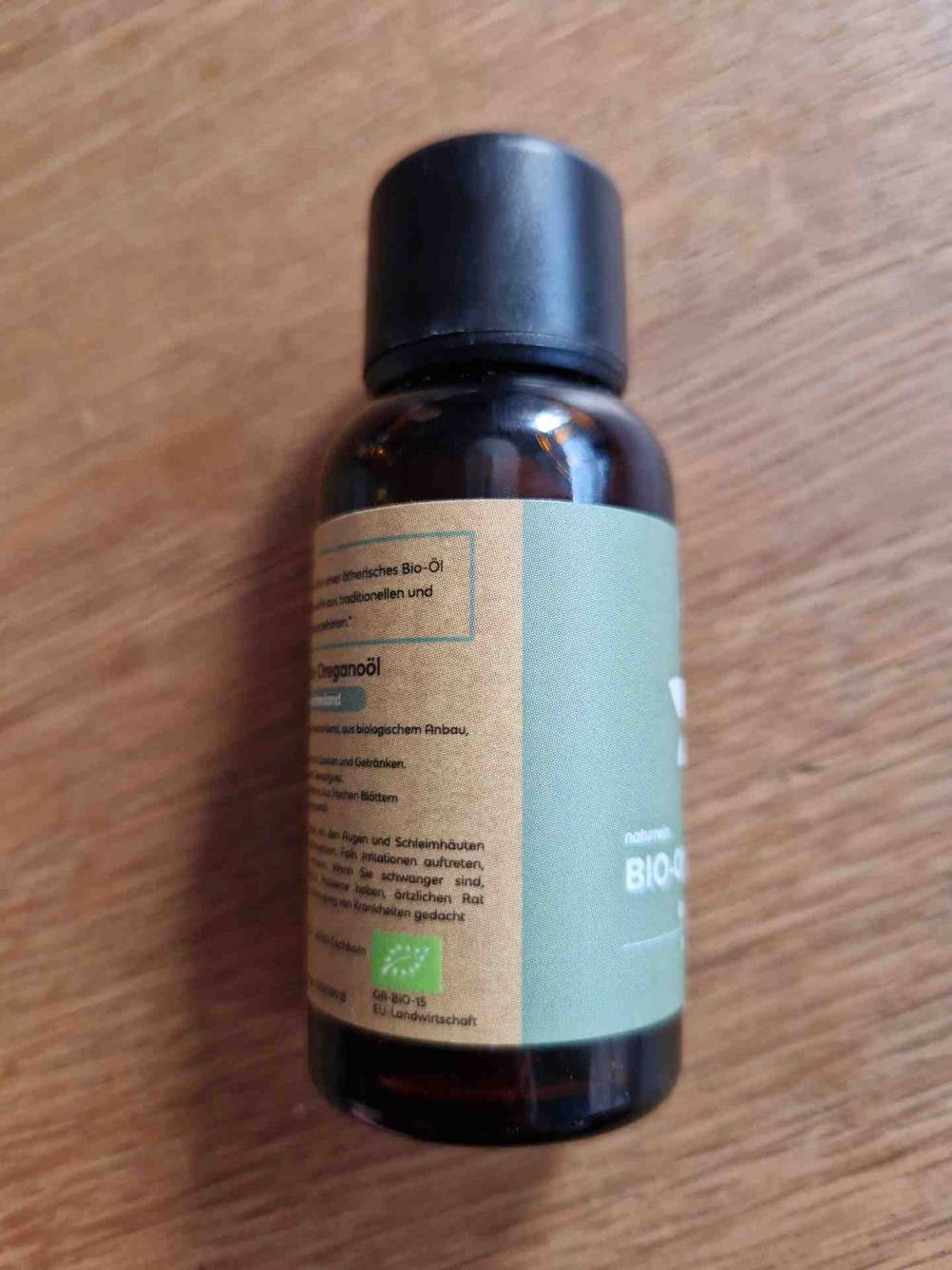 Seitenansicht einer Flasche des getesteten Oregano-Öls auf einer Holzfläche.