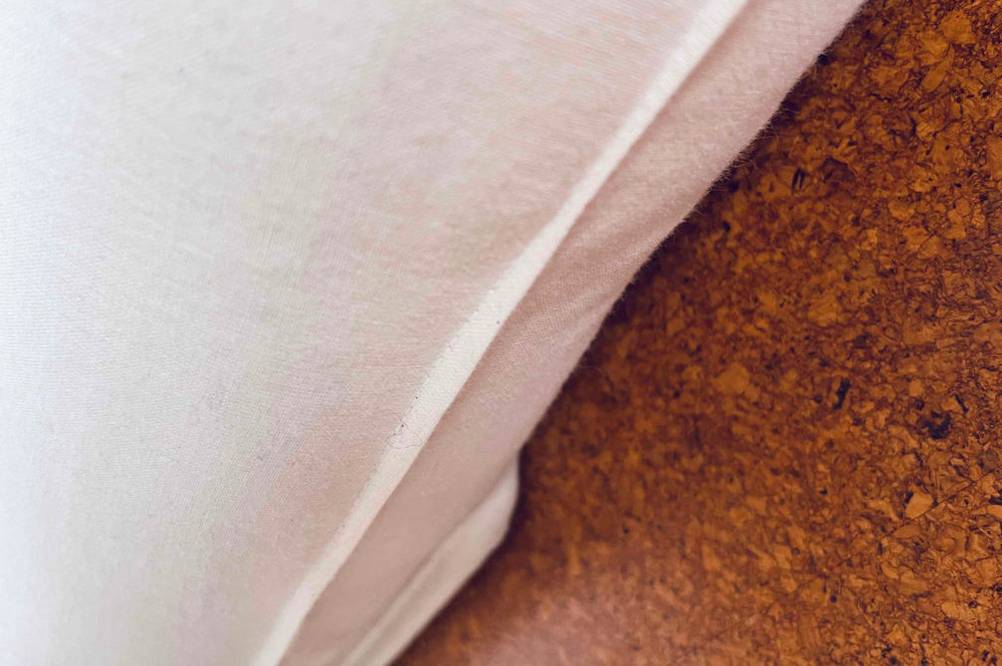 Im Test: Kindermatratzen-Material in Weiß im Detail auf einem Korkboden.