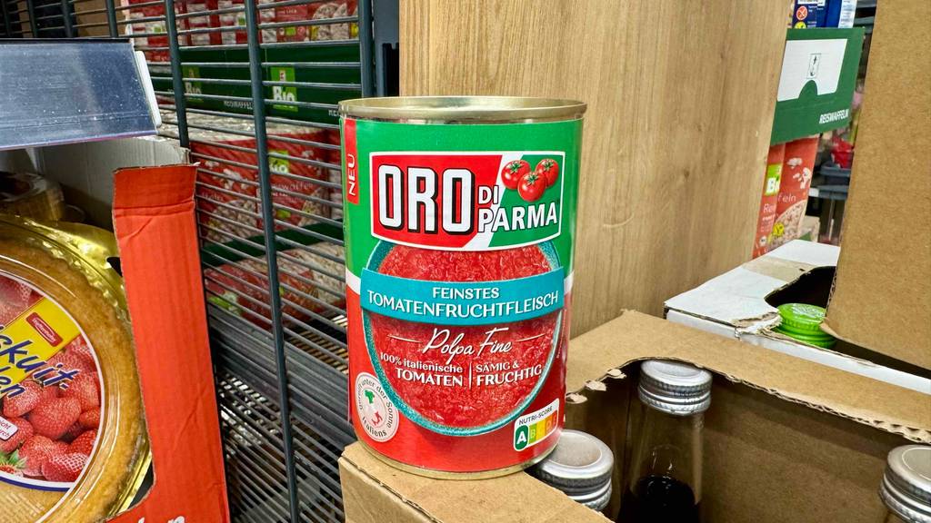 Im Test: Eine Dose Tomatensauce steht auf dem Eck eines Kartons mit Flaschen.