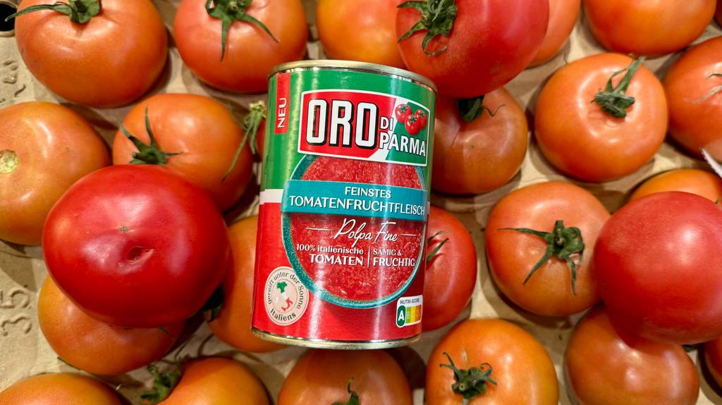 Im Test: Eine Dose Tomatensauce liegt auf mehreren Tomaten.
