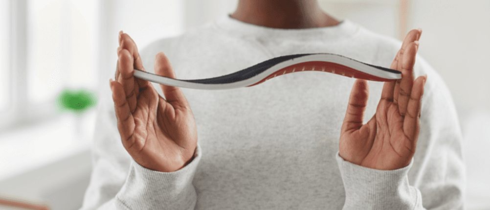 Orthopädische Einlegesohlen im Test: Eine Person hält eine Einlegesohle.