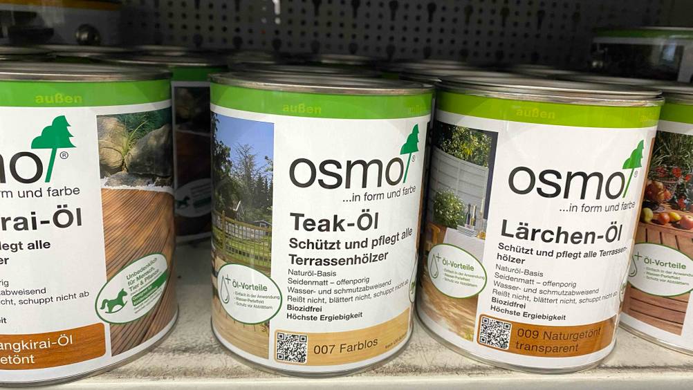 Teaköl getestet: Mehrere Dosen stehen nebeneinander in einem Verkaufsregal.