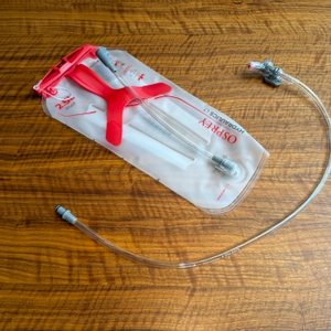 Die Osprey Hydraulics LT liegt neben dem Schlauch auf einem Tisch