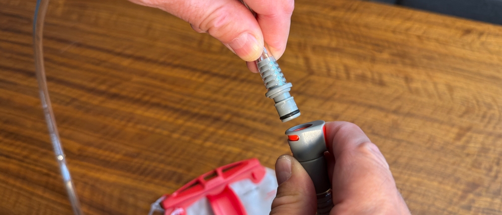 Eine Hand steckt den Schlauch in den Beutel der Osprey Hydraulics LT