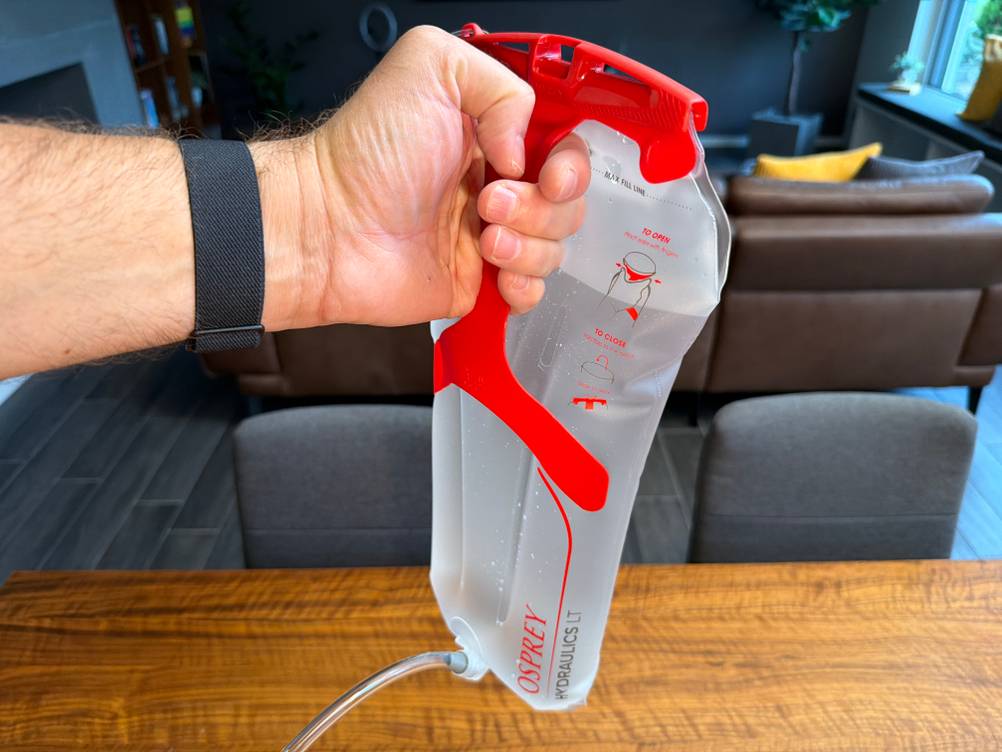 Eine Hand hält die gefüllte Osprey Hydraulics LT fest