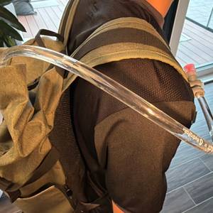 Der Schlauch der Osprey Hydraulics LT ist an einem Rucksack befestigt