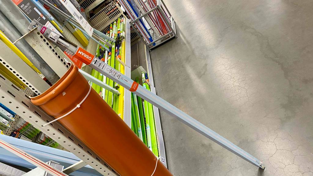 LED-Röhre 120 cm im Test: Eine verpackte Röhre steht vor einem Regal in einem großen Verkaufsraum.