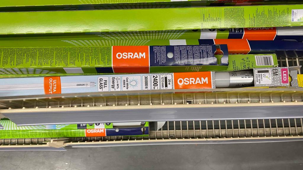 LED-Röhre 120cm im Test: Mehrere verpackte Röhren liegen gestapelt in einem Lochregal.
