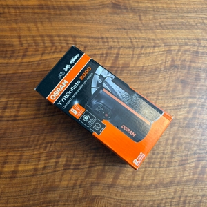 Der Karton vom Osram TyreInflate 2000 liegt auf einem Holztisch